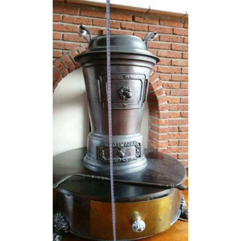 Gietijzeren kachel met voet en koperen lade (voor decoratie)